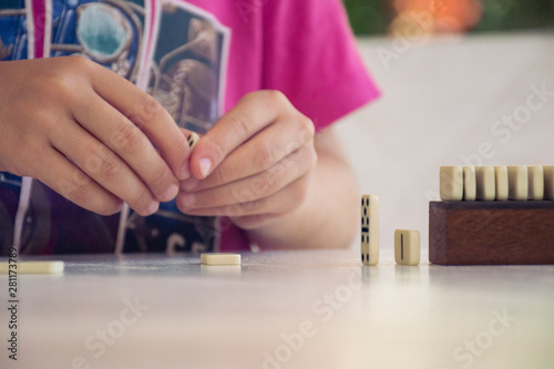 close up of child's hands playing domino