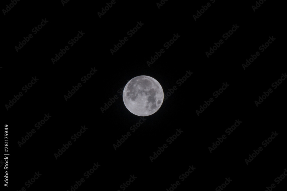 The full moon is captured against a night sky. The full moon is captured against a night sky.