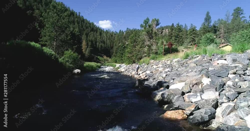 A fly fisherman casts along the banks of a high mountain river. A fly fisherman casts along the banks of a high mountain river.