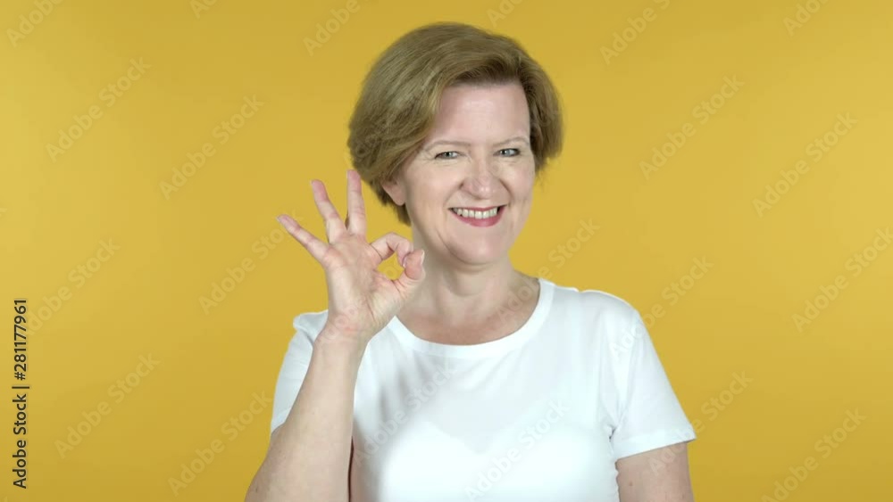 Okay Sign by Old Woman Isolated on Yellow Background Okay Sign by Old Woman Isolated on Yellow Background