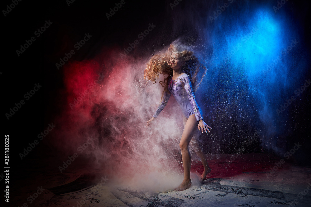 Obraz premium Beautiful teen girl with long blonde curly hair in a dark room with colored lights and clouds of flour