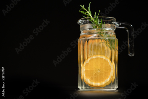 a glass jar of orange and rosemary infused water.