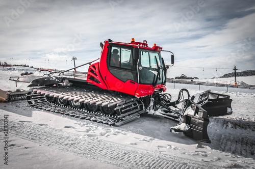 Obraz na plátně Red snow-grooming machine on snow