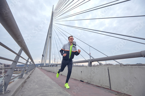 Sportsman working out / jogging on a big city urban bridge. © astrosystem