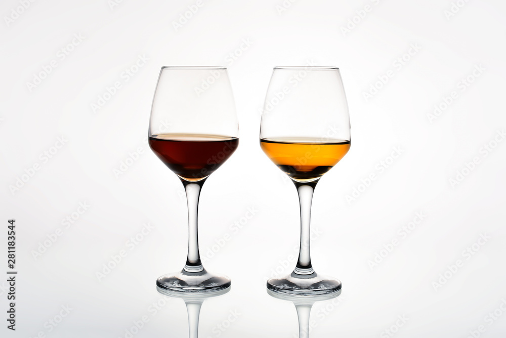 Glass of red and white wine on a white background. Side view. Glass of red and white wine on a white background. Side view.