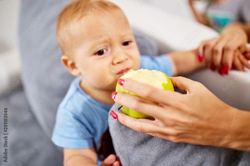 Parents feeding their baby with healthy green apple. Parents feeding their baby with healthy green apple.
