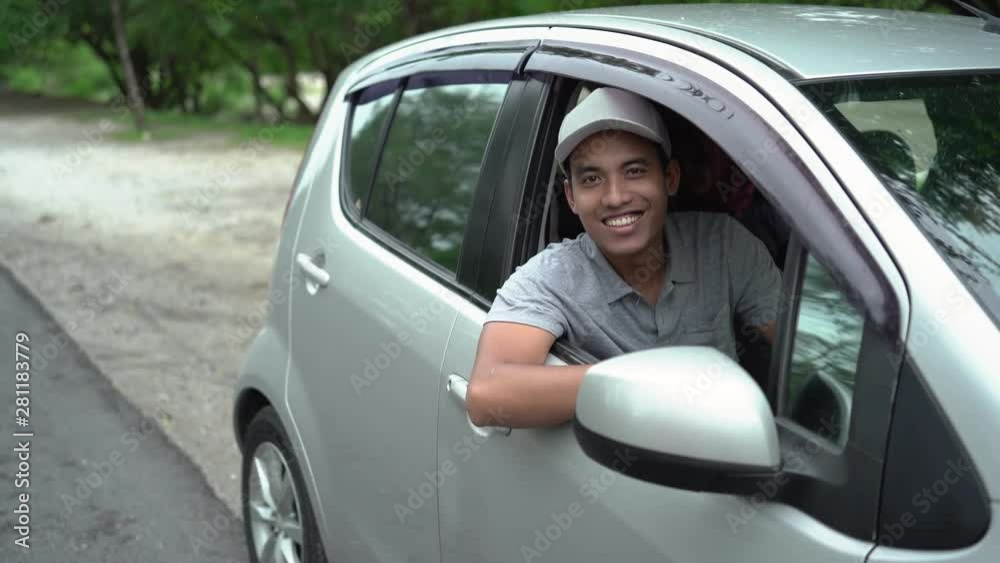 asian driver look out from the open window with smile look at camera asian driver look out from the open window with smile look at camera
