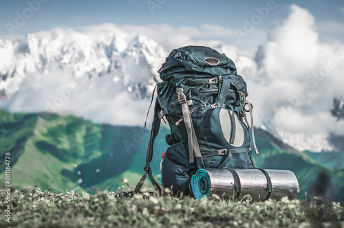 Tourist backpack and sleeping pad on a background of mountains photo