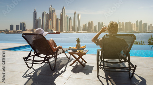 beautiful couple enjoys the view of the dubai skyline from the pool