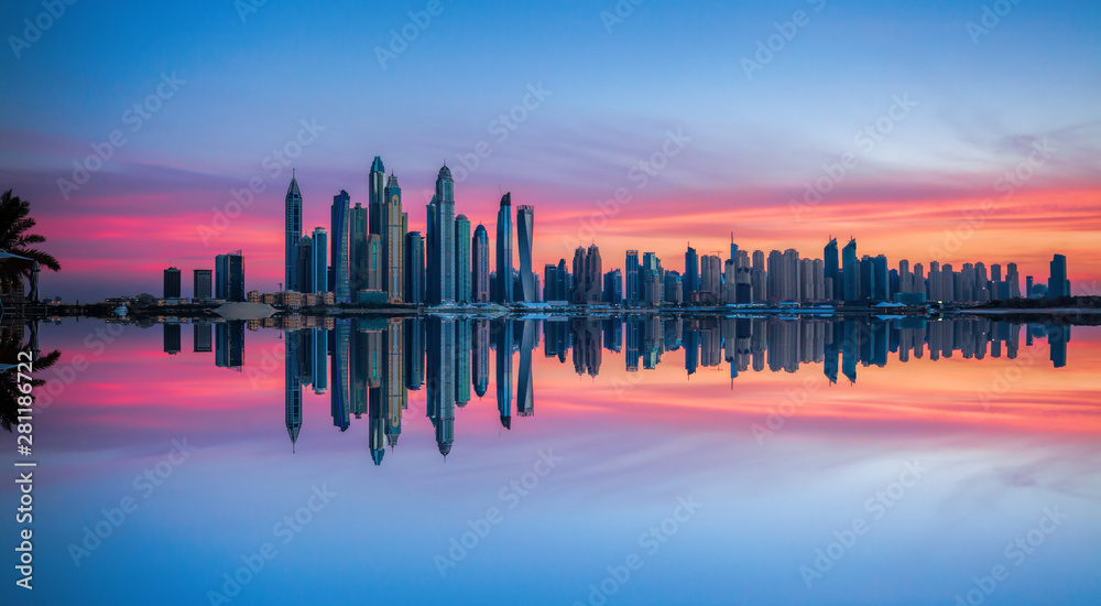 Skyline of Dubai Marina at a beautiful sunset with an infinity pool in front