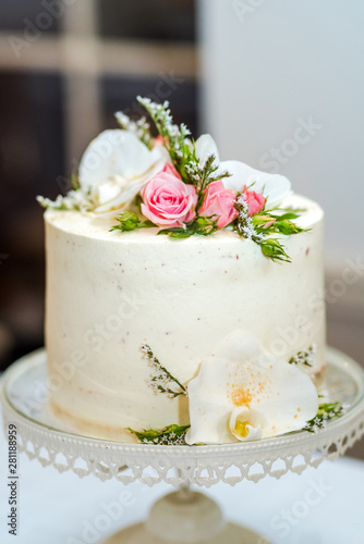 White cream wedding cake with flower decoration on it.
