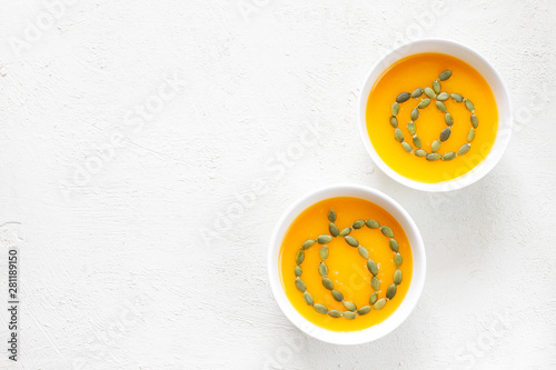 Pumpkin soup with parsley on a white wooden background