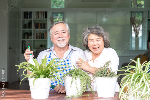 Asian senior couple smile watering plants take care of trees , happy couple gardening - lifestyle senior concept © suphaporn