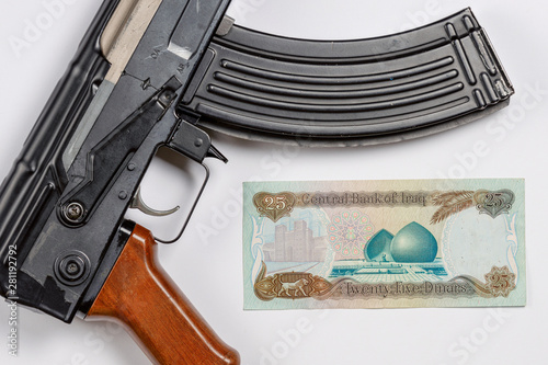 old Iraqi money depicting Saddam Hussein along with the Soviet AK 47 photo