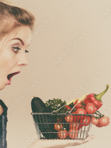 Woman with vegetables, shocked face expression photo