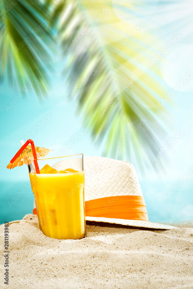 Table background with orange ice juice in a glass on a wooden table top with beautiful blue sky and ocean and palm tree view.