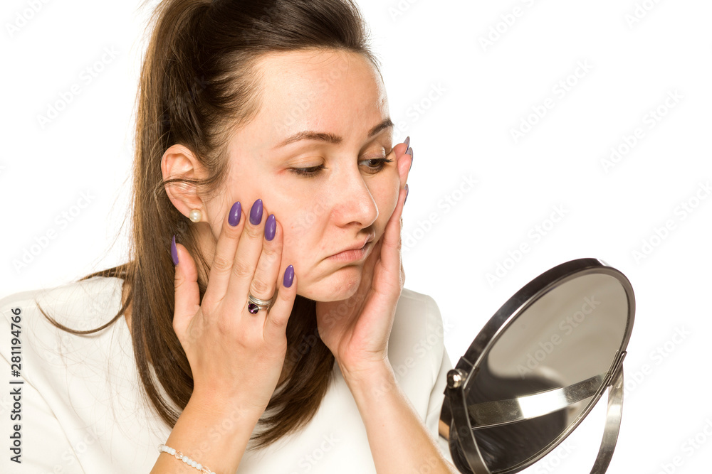 bored woman looking at herself in the mirror on white background bored woman looking at herself in the mirror on white background