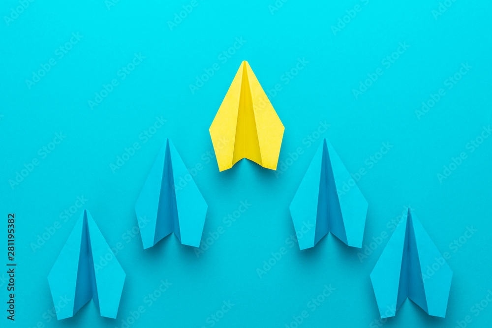 Leadership concept with paper planes over turquoise blue background with copy space. Top view of yellow plane leading blue ones. Flat lay image of business competition concept. Leadership concept with paper planes over turquoise blue background with copy space. Top view of yellow plane leading blue ones. Flat lay image of business competition concept.