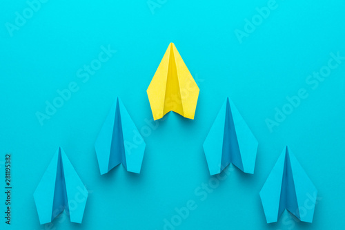 Leadership concept with paper planes over turquoise blue background with copy space. Top view of yellow plane leading blue ones. Flat lay image of business competition concept.