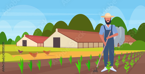 male gardener using hoe countryman hoeing ground with seeding plants field planting harvesting gardening eco farming concept farmland countryside landscape full length horizontal