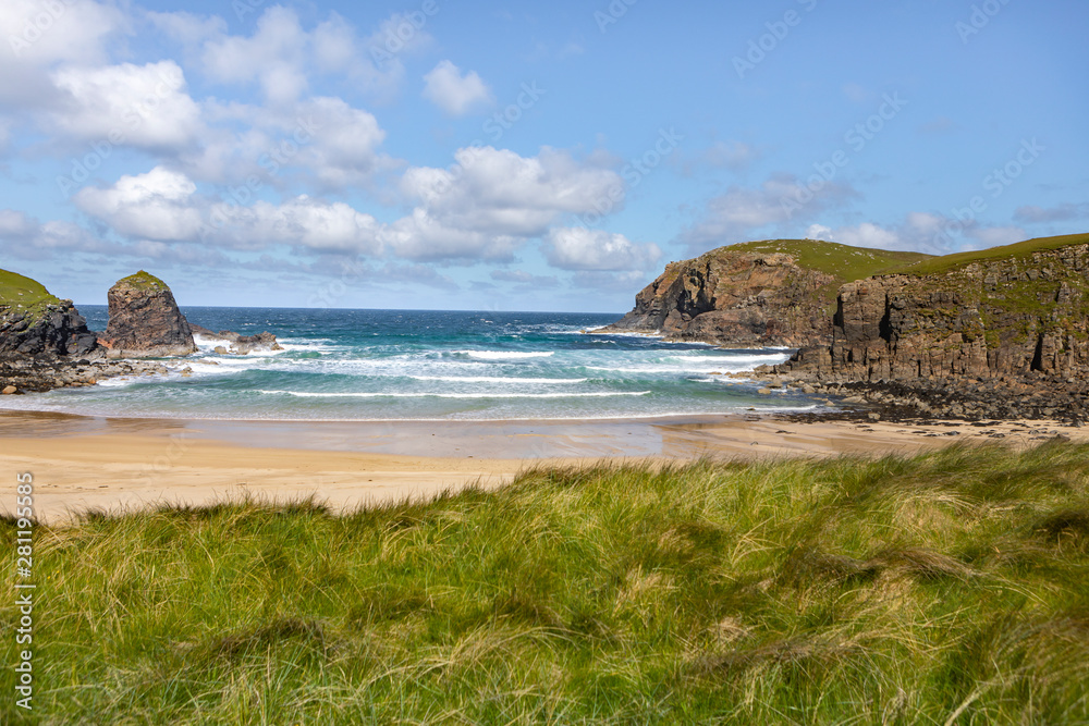 sandy bay with waves crashing onshore on the Isle of Lewis, Outer Hebrides in Scotland on a sunny day