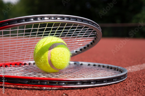 Tennis ball resting on top of a tennis racquet