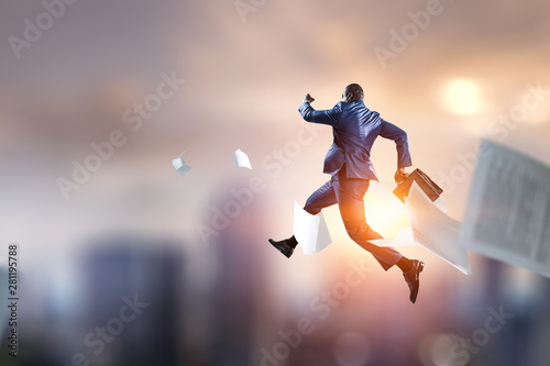running black businessman with briefcase and documents falling © Sergey Nivens