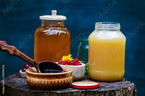 fresh sweet honey dripping in a wooden spoon in a ceramic bowl