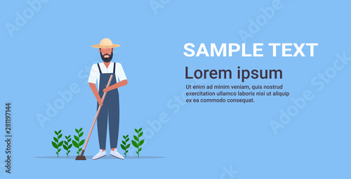male gardener using hoe countryman hoeing ground with seeding plants on vegetable field planting harvesting gardening eco farming concept full length horizontal copy space