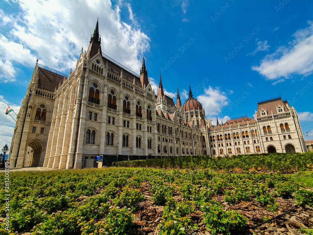 Panoramic view of the Hungarian parliament in Budapest on a beautiful summer day with clear blue sky. Side panoramic view of the Hungarian parliament in Budapest. 