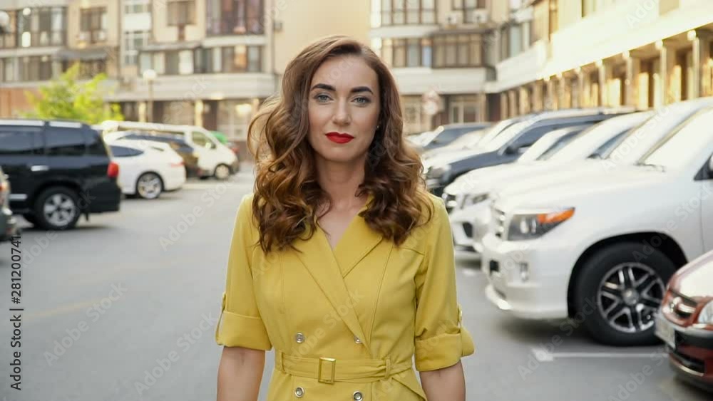 The camera monitors a young attractive girl in the parking lot.
