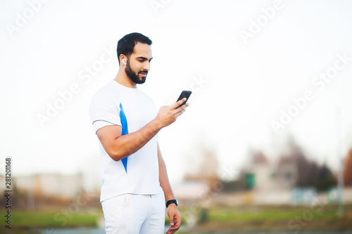 Man after working out in the city park and using his mobile phone