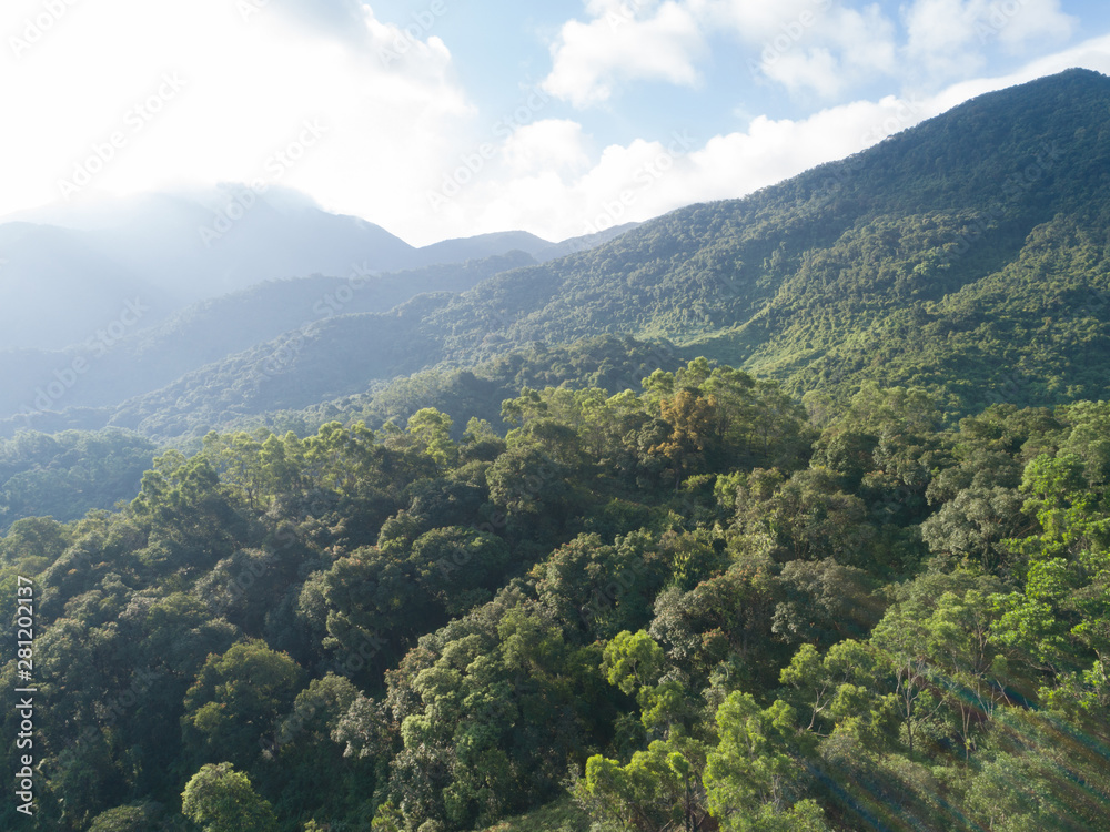 Aerial view of mountains with green dense tropical rainforests and morning fog in the sunrise