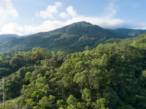 Fototapeta Naklejka Na Ścianę i Meble -  Aerial view of mountains with green dense tropical rainforests and morning fog in the sunrise