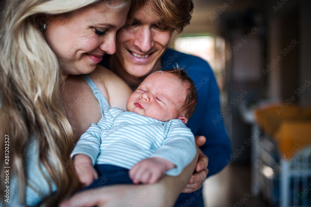 Beautiful young parents with a newborn baby at home.