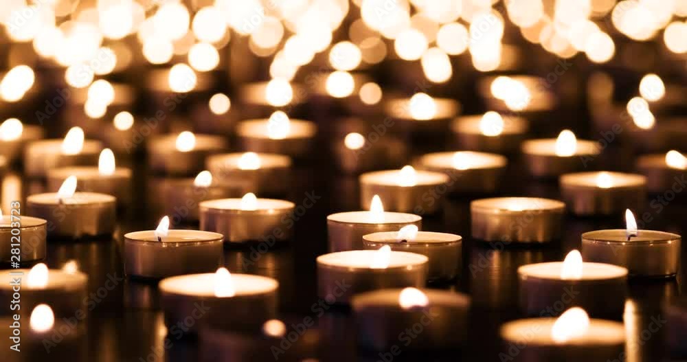 Flickering candles on black granite
