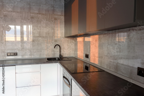 Fototapeta Naklejka Na Ścianę i Meble -  New modern empty kitchen interior in white and gray colors with sunlight, copy space. Kitchen appliances