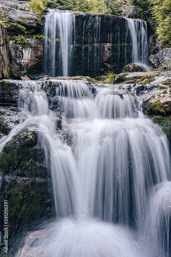 Waterfall photograph. Long exposure photo of a beautiful waterfall of Jedlova  Jizerske mountains  Czechia. Motion blurr water in a mountain creek in a deep forest. Alaska like stream with a rocks.