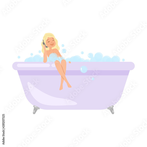 Cute blonde girl is taking a bath and talking on telephone