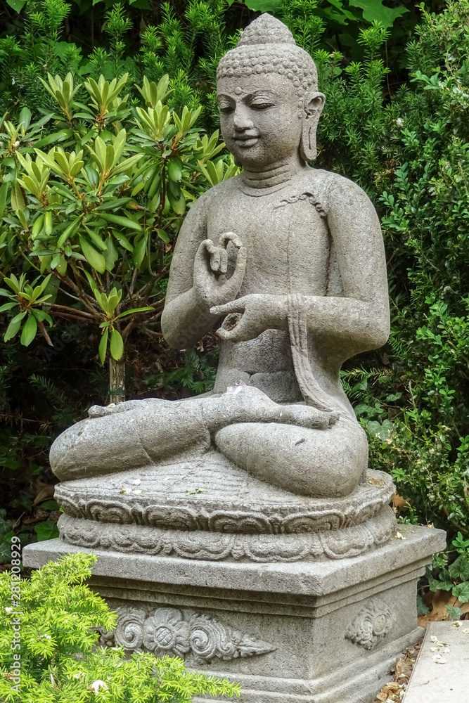 Garden sculpture of a young sitting buddha meditating