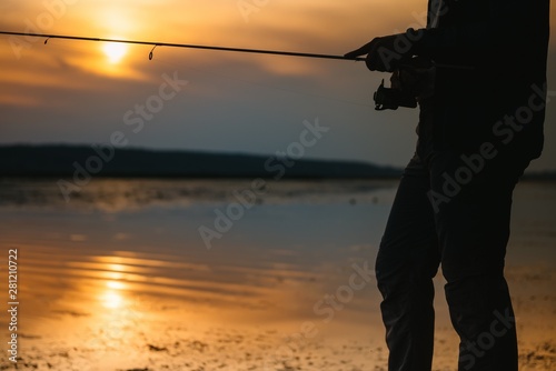 The fisherman's hands, holds the spinning rod, rotates the coil handle. Hobby and activity