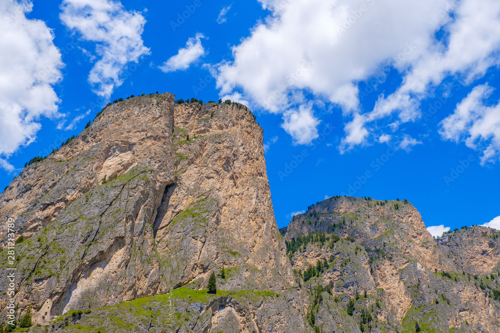 Mountain peaks at a blue sky with white clouds