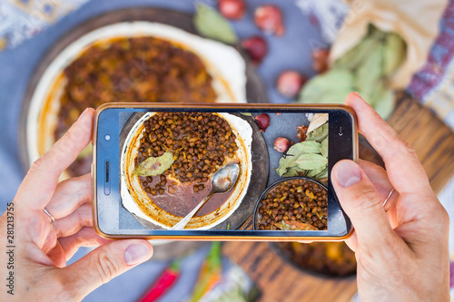 Photography Hands take phone photo of Indian food in cafe or restaurant
