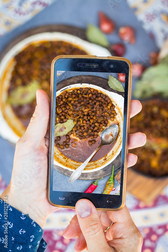 Canvas Print Hands take phone photo of Indian food in cafe or restaurant