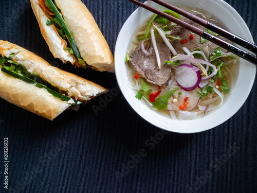 Vietnamese soup pho bo with banh mi ba and some traditional chopsticks photo