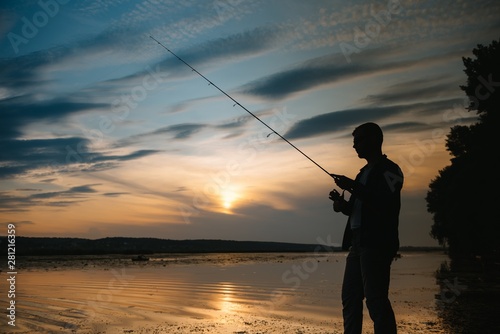 Fishing. spinning at sunset. Silhouette of a fisherman