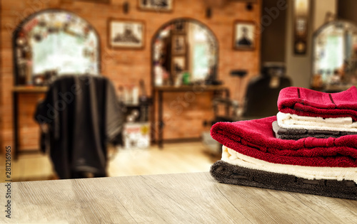 Table background with towels and blurred hairdresser and barber shop view.