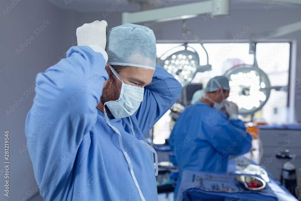 Naklejka premium Male surgeon wearing surgical mask in operation room at hospital