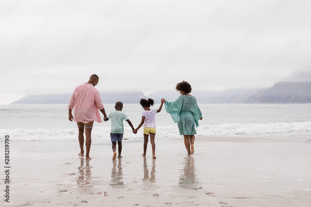 Family walking together hand in hand on the beach