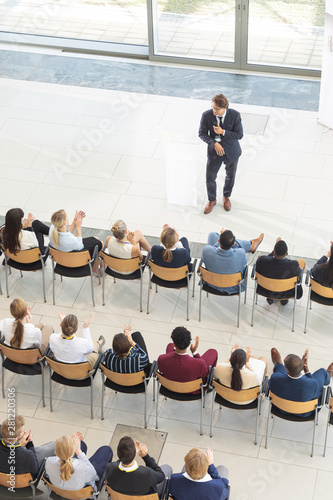 Diverse executives sat in conference room, looking speech